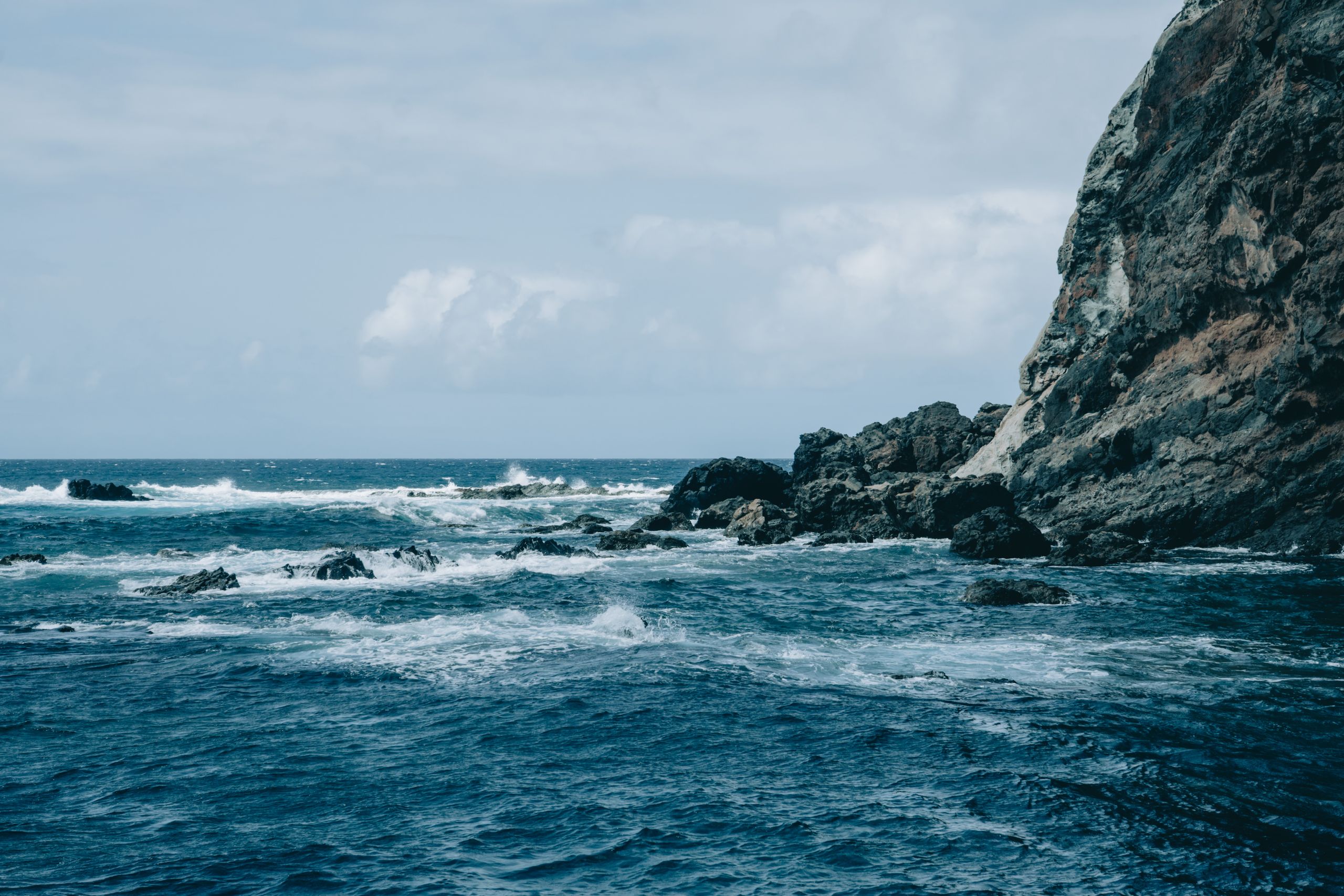 Powerful ocean waves crash against the rugged cliffs of Alojera, Canary Islands, Spain.